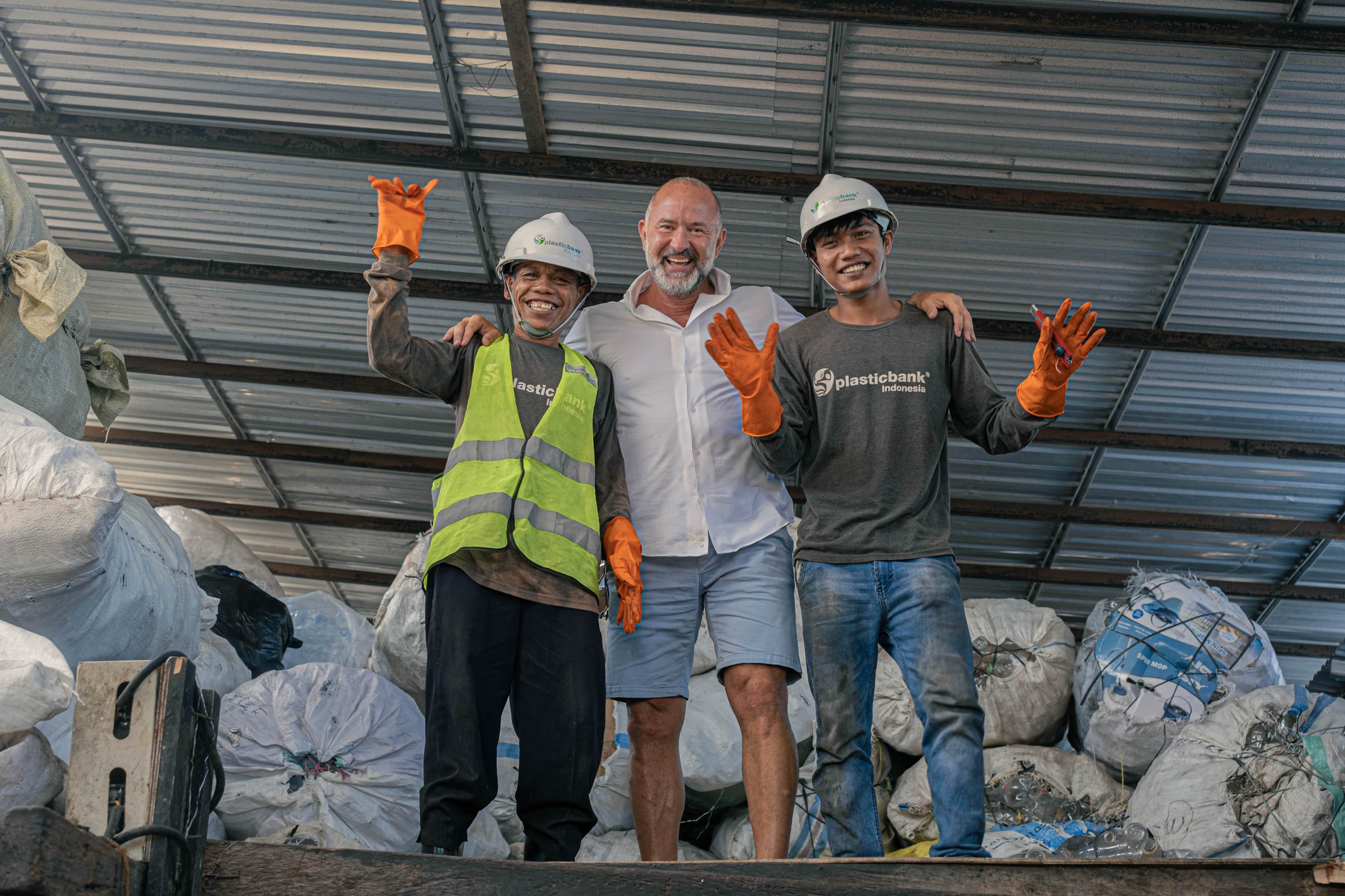 People gathering and recycling bottles as part of the Impact+ initiative
